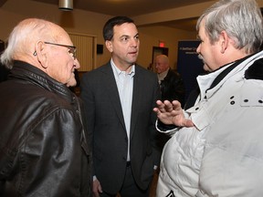 Ontario PC leader Tim Hudak held a town hall meeting Thurs. Nov. 28, 2013, in Leamington, Ont. to speak to the community about the closure of the Heinz plant. Hudak (C) speaks to Herm Dick, (L) and his son Greg Dick, Leamington farmers who have been growing tomatoes for Heinz since the 1950s. (DAN JANISSE/The Windsor Star)
