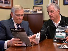 Ontario MPP Ernie Hardeman, left, and John Gignac, co-chair of the Hawkins-Gignac Foundation, look over carbon monoxide alarms in a handout photo. (THE CANADIAN PRESS/HO)