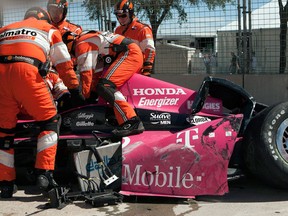 In this Oct. 6, 2013, file photo, safety team members work to remove driver Dario Franchitti, of Scotland, from his car after a crash during the second IndyCar Grand Prix of Houston auto race in Houston. The three-time Indianapolis 500 winner said Thursday, Nov. 14, 2013, that doctors have told him he can no longer race because of injuries sustained in an IndyCar crash last month. He fractured his spine, broke his right ankle and suffered a concussion in the Oct. 6 crash at Houston. (AP Photo/Juan DeLeon, File)