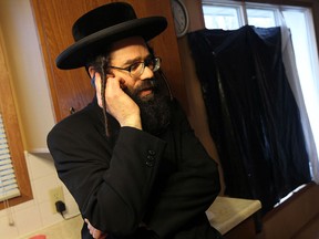 Uriel Goldman from the Jewish sect Lev Tahor talks on his phone in his home in a townhouse complex north of Chatham on Tuesday, Nov. 26, 2013.  (TYLER BROWNBRIDGE/The Windsor Star)