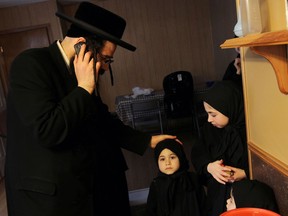 Uriel Goldman from the Jewish sect Lev Tahor talks on his phone in his new home in a townhouse complex north of Chatham, Ont., on Tuesday, November 26, 2013. The group has settled in the area after fleeing Quebec.           (TYLER BROWNBRIDGE/The Windsor Star)
