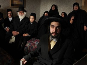Nachman Helbrans, front-centre, is pictured with two families of the Jewish fundamentalist group, Lev Tahor, where they are staying at the Ramada Limited Windsor, Sunday, Nov. 24, 2013.  Approximately 200 members of the group left their home in Saint-Agathe-des-Monts, Que. for Ontario in the midst of a child neglect investigation.  They plan to settle in Chatham-Kent.  (DAX MELMER/The Windsor Star)
