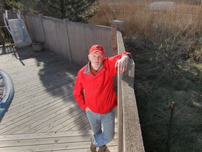 John Findlater, a resident in the 2800 block of Mangin Crescent in Windsor, Ont., stands next to his backyard fence which runs along the parkway project. He is upset to learn that plans to knock down the fence have changed. The new plan calls for the existing wall to stand and a second wall be built a metre away. (DAN JANISSE/The Windsor Star)