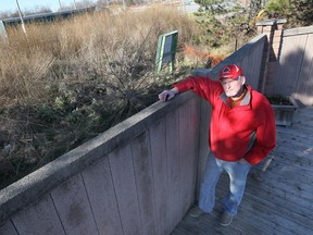 John Findlater, a resident in the 2800 block of Mangin Crescent in Windsor, Ont., stands next to his backyard fence which runs along the parkway project. He is upset to learn that plans to knock down the fence have changed. The new plan calls for the existing wall to stand and a second wall be built a metre away. (DAN JANISSE/The Windsor Star)