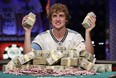 Ryan Riess holds up two bricks of $100 bills after winning the World Series of Poker Final Table, Tuesday, Nov. 5, 2013, in Las Vegas. Riess defeated runner up Jay Farber for an $8.4 million payout (AP Photo/Julie Jacobson)