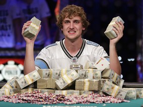 Ryan Riess holds up two bricks of $100 bills after winning the World Series of Poker Final Table, Tuesday, Nov. 5, 2013, in Las Vegas. Riess defeated runner up Jay Farber for an $8.4 million payout (AP Photo/Julie Jacobson)