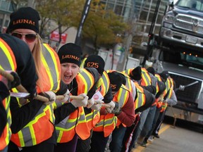 Team LiUNAtics, from LiUNA Local 625, compete in the Ram Tough Truck Pull for United Way on Riverside Drive West in downtown Windsor, Sunday, Nov. 3, 2013.  Eleven teams of 15 members competed by pulling a Chrysler Group auto transport loaded with six Ram 1500 trucks 50 metres in the shortest time.  (DAX MELMER/ The Windsor Star)