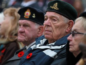 Martin Vermeer, 80, centre-right, and Bill Major, 81, centre-left, both Korean War veterans, attend the Remembrance Day ceremony at the cenotaph in downtown Windsor, Monday, Nov. 11, 2013.  (DAX MELMER/The Windsor Star)