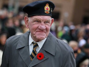 Bill Major, 81, a veteran of the Korean War, hands out red poppies  during the Remembrance Day ceremony at the cenotaph in downtown Windsor, Monday, Nov. 11, 2013.   (DAX MELMER/The Windsor Star)