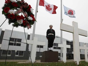 Jacob Brodie, a member of the Royal Canadian Sea Cadet Corp #48 Agamemnon in Windsor, Ont., stands as a honour guard, Monday, Nov. 11, 2103, in front of St. Joseph Catholic high school in Windsor, Ont. where students and staff set up crosses and wreaths for Remembrance Day.  (DAN JANISSE/The Windsor Star)