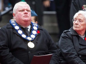 Margaret Delmore, left, the ceremonial Memorial Cross Mother, sits next to Toronto Mayor Rob Ford at the cenotaph during the Remembrance Day service in Toronto on Monday, November 11, 2013. (THE CANADIAN PRESS/Chris Young)