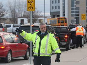 A City of Windsor parking enforcement officer is shown Tuesday, Nov. 19, 2013, in front of the Talbot Trail Public School in Windsor, Ont. The city has been handing out tickets to parents dropping off and picking up their kids while parked in no parking zones.     (DAN JANISSE/The Windsor Star)