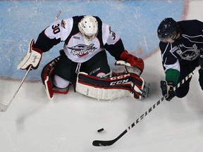 Windsor goalie, Dalen Kuchmey, left, makes a stop against Plymouth's Connor Chatham as the Windsor Spitfires host the Plymouth Whalers at the WFCU Centre, Sunday, Nov. 24, 2013.  Windsor lost 2-1.  (DAX MELMER/The Windsor Star)