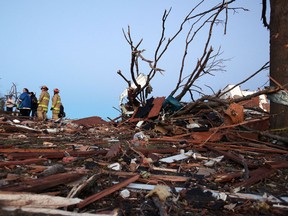 Residents and firefighters sort through debris after a tornado struck on November 17, 2013 in Washington, Illinois. Several tornadoes touched down across the Midwest today with at least three people reported dead in Illinois. (Photo by Tasos Katopodis/Getty Images)