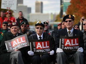 Veterans, from left, Ralph Mayville, Dorothy Grondin, and Wilford Renaud, join nearly a hundred people protesting the closure of a Windsor district Veterans office, outside City Hall, Friday Nov. 8, 2013. (DAX MELMER/The Windsor Star)