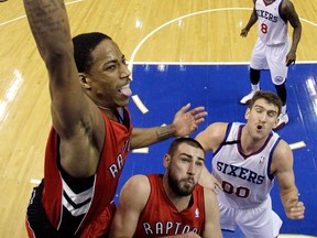 Toronto's DeMar DeRozan, left, goes up for a dunk against Philadelphia's Spencer Hawes. (AP Photo/Matt Slocum)