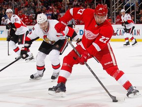 Detroit's Kyle Quincey, right, is checked by Ottawa's Milan Michalek at Joe Louis Arena. (Photo by Gregory Shamus/Getty Images)