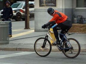 An unidentified cyclist watches over his shoulder while peddling south on Ouellette Avenue November 27, 2013.  (NICK BRANCACCIO/The Windsor Star)
