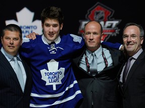 Toronto draft pick Frederik Gauthier stands with officials from the Maple Leafs after being chosen 21st overall in the 2013 NHL Draft. (AP Photo/Bill Kostroun)