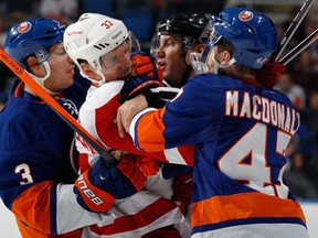 Detroit's Mikael Samuelsson, left, is hit by New York's Travis Hamonic, left, and Andrew MacDonald Friday at the Nassau Veterans Memorial Coliseum. (Photo by Bruce Bennett/Getty Images)