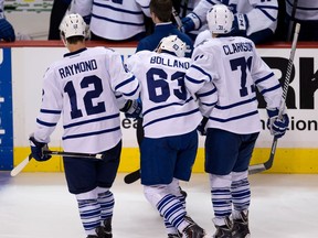 Toronto's Dave Bolland, centre, is helped off the ice by Mason Raymond, left, and David Clarkson against the Vancouver Canucks. (THE CANADIAN PRESS/Darryl Dyck)