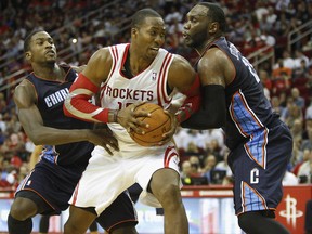 Houston's Dwight Howard, centre, is double teamed by Al Jefferson, right, and Michael Kidd-Gilchrist of the Charlotte Bobcats. (Photo by Bob Levey/Getty Images)