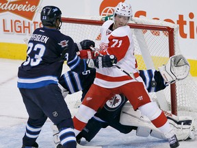 Jets goaltender Al Montoya, back, stops the shot with defenceman Dustin Byfuglien, left, battling with Detroit's Daniel Cleary. (THE CANADIAN PRESS/John Woods)