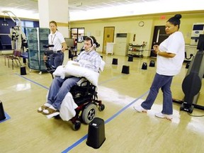 Jason DiSanto navigates an obstacle course in an electric-powered wheelchair by issuing commands with a magnetic tongue piercing. The 50-meter-long course, at the Shepherd Center in Atlanta, Ga., included 13 turns and 24 obstacles, requiring tongue drive users to make U-turns, move in reverse and negotiate a loop. (AP /Georgia Tech, Gary Meek)