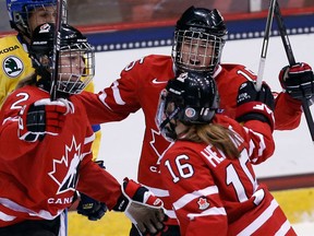 Ruthven's Meghan Agosta-Marciano, left, celebrates with Melodie Daoust, centre, and Jayna Hefford at the Four Nations Cup Friday in Lake Placid, N.Y. (AP Photo/Mike Groll)