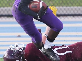 Assumption's Louis Jodin, top, is tripped by Leamington's Todd Jones Friday at Alumni Field. (DAN JANISSE/The Windsor Star)