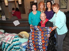 The organization "In Honour of the Ones We Love" donated dozens of knitted blankets to palliative care patients on Friday Nov. 22, 2013 at the Dr. Y Emara Centre for Healthy Aging and Mobility building in Windsor, Ont. Patient Rick Gamberta poses with Julia Lopez, (L), Teresa Silvestri, Anita Imperioli and Julie Lawrence from the organization. (DAN JANISSE/The Windsor Star)