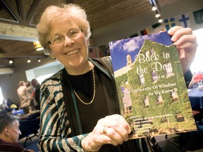 Kathleen McCrone, general editor and former history professor, holds up a copy of Back in the Day – 1963-2013: The University of Windsor as We Knew It at the Canterbury College in Windsor Friday, Nov. 15, 2013. (JOEL BOYCE/The Windsor Star)