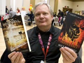 Local author Mick Ridgewell holds up his two novels The Nightcrawler and Evil Never Dies at the 2013 Windsor-Essex Book Expo at Caboto Hall Sunday, Nov. 24, 2013. (JOEL BOYCE/The Windsor Star)