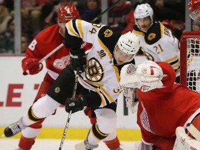Boston's Carl Soderberg, centre, battles for puck control in front of Wings goalie Jonas Gustavsson at Joe Louis Arena on November 27, 2013 in Detroit.  (Leon Halip/Getty Images)