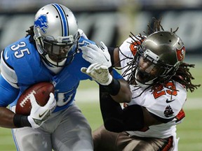 Detroit running back Joique Bell, left, is stopped by Tampa Bay's Mark Barron at Ford Field in Detroit, Sunday, Nov. 24, 2013. The Bucs won 24-21. (AP Photo/Duane Burleson)