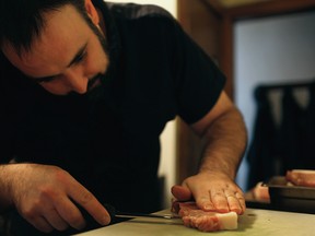 Rino Bortolin slices meat at a butcher demonstration, from Rino’s Kitchen: Cooking Local in Windsor & Essex County, by Rino Bortolin. (Photo by Dax Melmer)