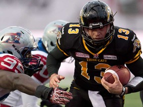 Hamilton quarterback Dan LeFevour, right, runs in the game winning touchdown past Montrea defensive tackle Moton Hopkins in overtime of the East Division semifinal in Guelph Sunday, November 10, 2013. (THE CANADIAN PRESS/Frank Gunn)