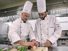 St. Clair College executive chef Steven Meehan, left, teaches Darnell Roberts, an apprentice prep-cook, at the St. Clair Centre for the Arts. A special program is allowing aspiring chefs the chance to learn the trade. (DAN JANISSE / The Windsor Star)