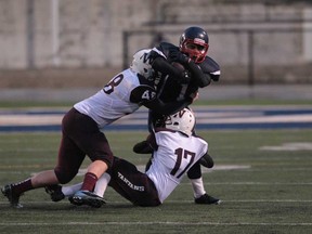 Cardinal Carter running back Chris Tannous, centre, is tackled by  Wallaceburg defenders during the SWOSSAA football championship at Alumni Field on November 21, 2013. (JASON KRYK/The Windsor Star)