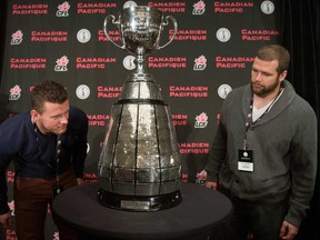 Saskatchewan wide receiver Aaron Hargreaves, left, and running back Daryl Stephenson, a former Windsor Lancer, look at the Grey Cup Thursday, Nov. 21, 2013 in Regina. (THE CANADIAN PRESS/Ryan Remiorz)