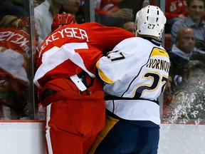 Detroit's Danny DeKeyser, left, is checked into the boards by Nashville's Patric Hornqvist Nov. 19, 2013. DeKeyser is expected to be out for at least three to four weeks with a separated left shoulder. (AP Photo/Paul Sancya)