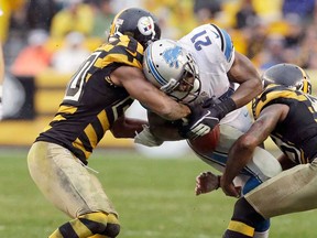 Detroit running back Reggie Bush, centre. has the football stripped by Pittsburgh's Will Allen, left, and Ryan Clark in Pittsburgh, Sunday, Nov. 17, 2013. (AP Photo/Gene J. Puskar)