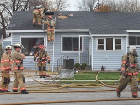 Essex Fire and Rescue Service firefighters work on the scene of house fire, Monday, Nov. 11, 2013, at 156 Albert St. in Essex, Ont. The fire started at approximately 9 a.m. and resulted in $100,000 damage. Two dogs were removed from the home safely. A pet snake died. (DAN JANISSE/The Windsor Star)