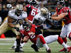 Atlanta QB Matt Ryan, centre, is sacked by New Orleans' Akiem Hicks, left, as the Falcons' Sam Baker, right, blocks Saints linebacker Parys Haralson in New Orleans Sept. 8, 2013. The Falcons host the Saints Thursday to kick off Week 12 in the NFL. (AP Photo/Bill Haber)