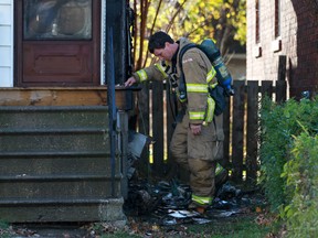 A Windsor firefighter inspects the side of a home at 995 McEwan Ave., after it caught fire, Friday, Nov. 15, 2013.  The fire was quickly contained.  No injuries are reported.  (DAX MELMER/The Windsor Star)