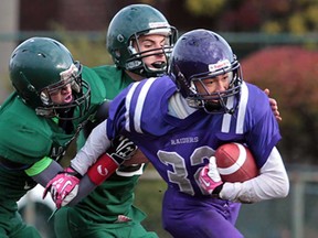 Assumption's Mony Keo, right, is tackled by Lajeunesse defenders Mo Gharib and Justin Ghanem during the WECSSAA senior boys playoff action at Windsor Stadium on November 4, 2013. Assumption won 42-21. (JASON KRYK/The Windsor Star)