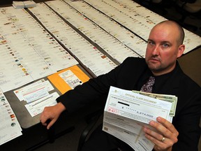 Const. Rob Durling of the Windsor police financial crimes unit shows hundreds of pieces of mail involved in a sweepstakes scam — one of many schemes that target seniors. (Nick Brancaccio / The Windsor Star)