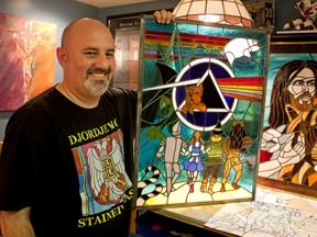 Robert Djordjevic, a local abstract artist, holds up a rock and roll themed stain glass window, The Dark Side of Oz, he created. The 40-year-old local abstract artist uses his unique vision and applies them to glass, a project he has never seen before. (JOEL BOYCE/The Windsor Star)
