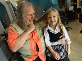 Ken and Paisley Koekstat have a picture taken prior to having their hair cut for cancer at Platinum Professionals in Windsor on Wednesday. (TYLER BROWNBRIDGE / The Windsor Star)