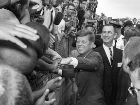 U.S. President John F. Kennedy shakes hands of spectators in Tampa, Fla. on Nov. 18, 1963, where he gave a speech commemorating the 50th anniversary of the first scheduled passenger airplane flight. (Associated Press files)